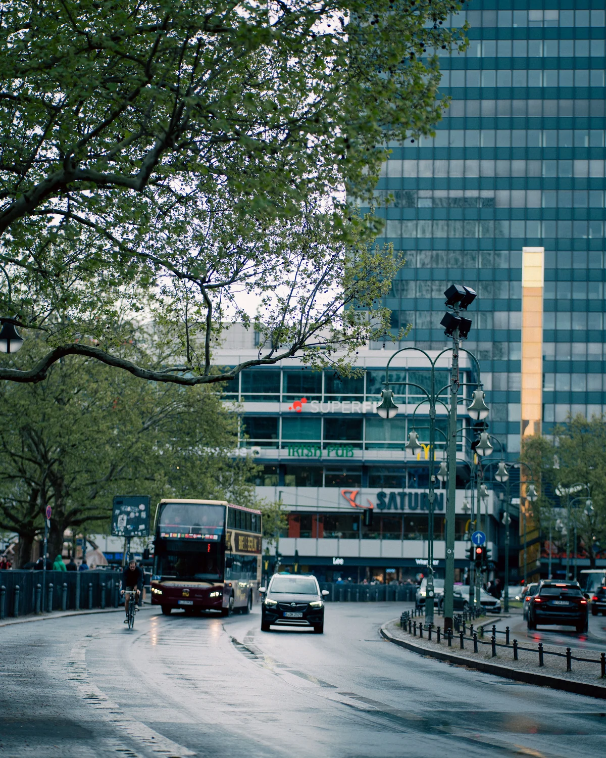 Regennasse Stadtstraße in Berlin mit Linienbus und Verkehr